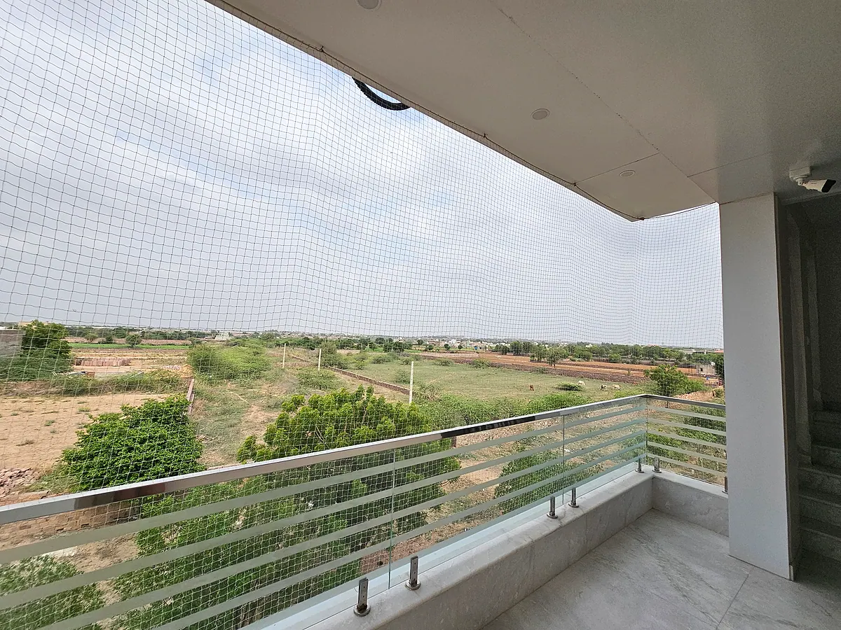 Open balcony with railing, protective mesh and views across the surrounding neighbourhood