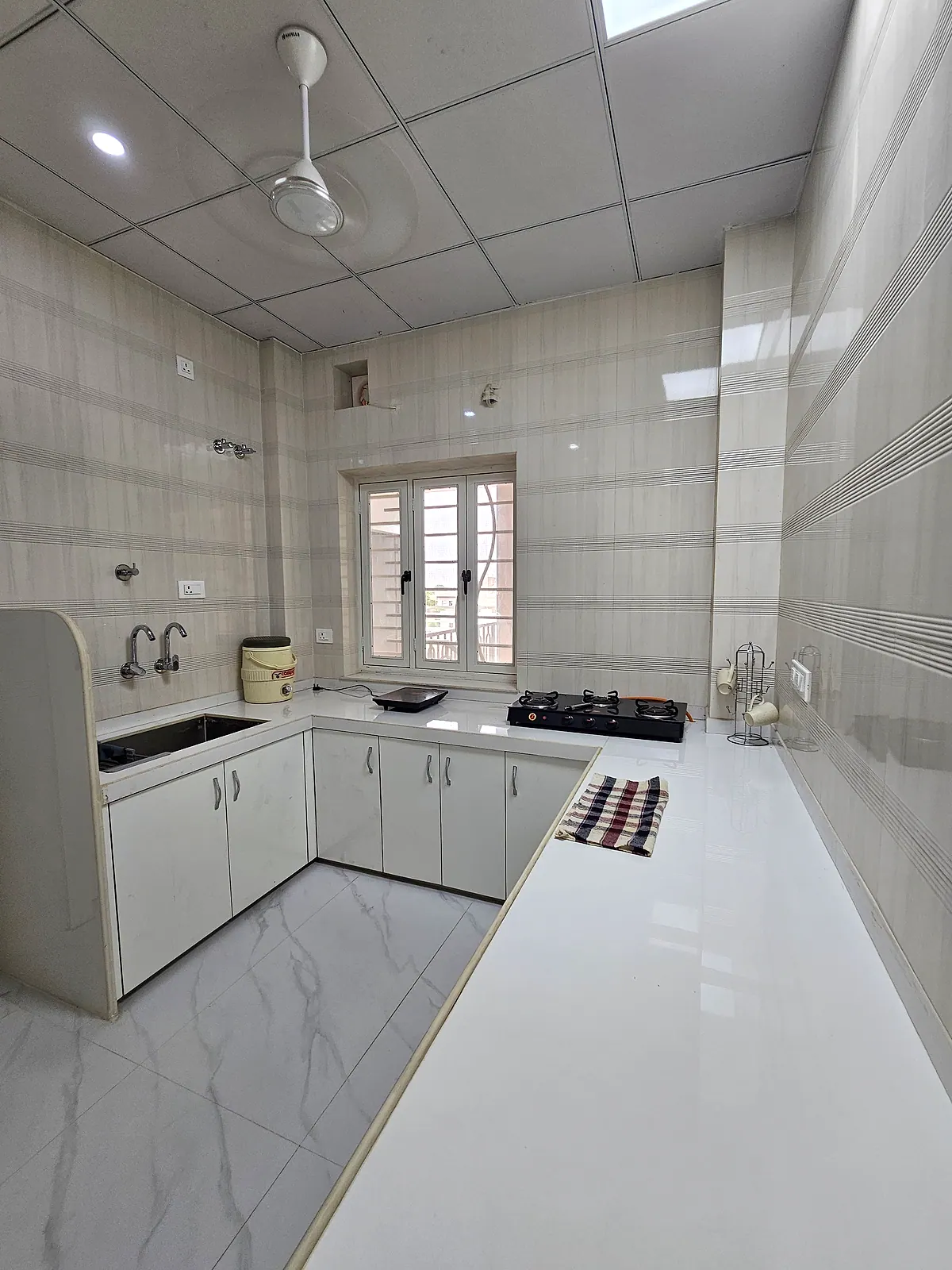 Additional view across the shared kitchen counters, cabinets, sink and cooking units
